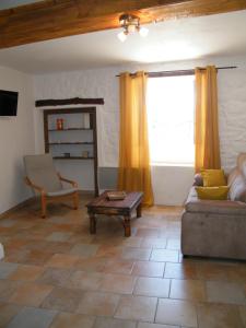 sala de estar con sofá y mesa en La petite Oustal, en Marseillette