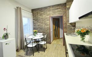cocina y comedor con mesa y sillas en Apartments by the lake with fireplace en Trakai