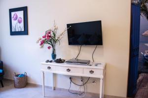 a white table with a television on top of it at António B in Alvor