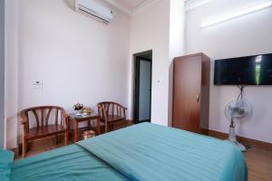 a bedroom with a green bed and a table and chairs at Motel Xuân Hòa in Bắc Ninh