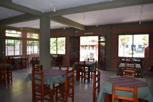 a restaurant with wooden tables and chairs and windows at Camino a Termas in San Salvador de Jujuy