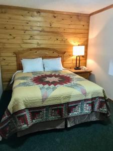 1 dormitorio con 1 cama con pared de madera en Centerstone Resort Lake-Aire en Tomahawk