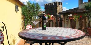 een tafel met een fles wijn en een glas bij La Terrazza sul Borgo - Montefioralle Apartment in Greve in Chianti