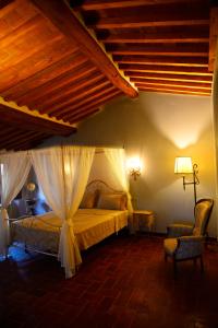 een slaapkamer met een bed met een witte baldakijn bij La Terrazza sul Borgo - Montefioralle Apartment in Greve in Chianti