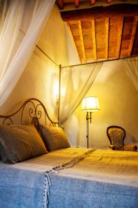 a bedroom with a bed with a lamp and curtains at La Terrazza sul Borgo - Montefioralle Apartment in Greve in Chianti