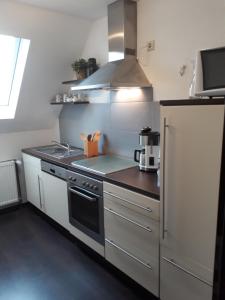 a kitchen with a stove and a refrigerator at Ferienwohnung Eiernest in Briedeler Heck