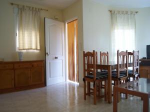 Un comedor con mesa y sillas y una cocina. en Chalet San Antonio LEK, en Peñíscola