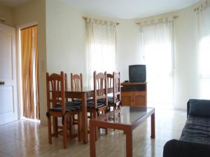 Una sala de estar con una mesa y sillas y un sofá. en Chalet San Antonio LEK, en Peñíscola