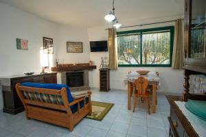 ein Wohnzimmer mit einem Tisch, Stühlen und einem Kamin in der Unterkunft Villetta Fenosa in Marina di Camerota