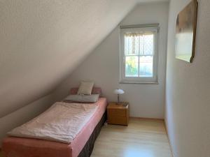 ein kleines Schlafzimmer mit einem Bett und einem Fenster in der Unterkunft Haus Willer in Erding