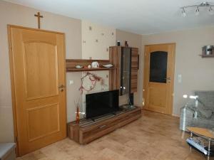 ein Wohnzimmer mit einem TV und einem Kreuz an der Wand in der Unterkunft Ferienwohnung Eichsfeld in Heilbad Heiligenstadt