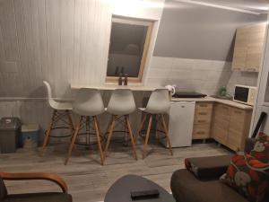 - une cuisine avec une table, 4 chaises et un évier dans l'établissement U Janka, à Wisła
