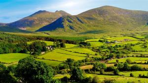 a green valley with mountains in the background at The Mournes view Farmhouse in Newcastle