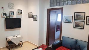 uma sala de estar com um sofá e uma televisão em Appartement au Centre de Martil em Martil