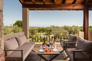 a patio with couches and a table with drinks on it at Five Senses Luxury Villas in Vourvourou