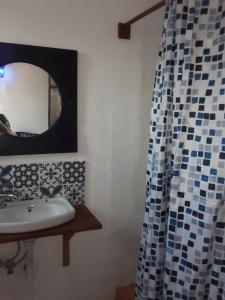 ein Badezimmer mit Waschbecken und Spiegel in der Unterkunft Gecko Cottage in Bagamoyo