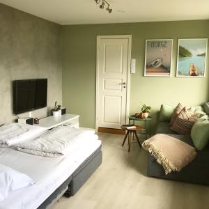 a bedroom with a bed and a couch and a tv at City View Studio Apartment in Ålesund