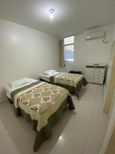 マセイオにあるF&F INN a 50 mts da Praia de Ponta Verdeのベッド2台とキッチンが備わる客室です。