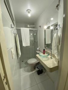 uma casa de banho com um chuveiro, um WC e um lavatório. em F&F INN a 50 mts da Praia de Ponta Verde em Maceió