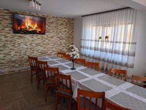 a dining room with a table and chairs and a fireplace at Angela in Polovragi