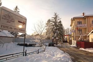 una strada ricoperta di neve accanto a un edificio di Готель Баронський Двір a Černivci