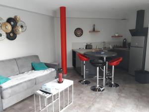 a living room with a couch and a table and a kitchen at Le Plein Soleil in Grésy-sur-Aix