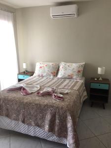 a bedroom with a bed with two tables and a fan at Condomínio Brisas do Amor in Pipa