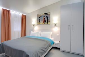 1 dormitorio con 1 cama y una pintura en la pared en Arena Apartments, en Kiev