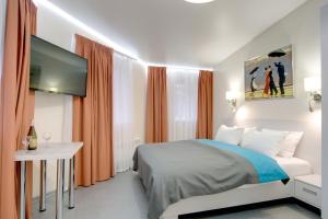 Dormitorio con cama, escritorio y TV en Arena Apartments, en Kiev