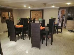 a dining room with a black table and chairs at Max B&B in East London