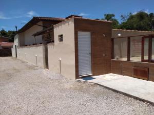a building with a garage with a door on it at Chalés São Mateus in Ubatuba