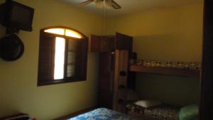 ein Schlafzimmer mit zwei Etagenbetten und einem Fenster in der Unterkunft Casa 200m da praia 3 dorm. p/ 12 pessoas in Peruíbe + 38 Fotos