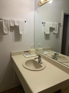a bathroom with a sink and a mirror at La Vista Inn in Clovis +17 photos