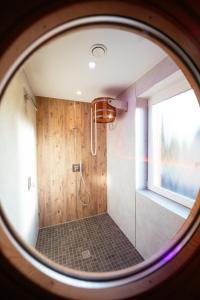La salle de bains est pourvue d'une douche avec une porte en verre. dans l'établissement Ferienhaus Hünzingen № 2, à Kalyves