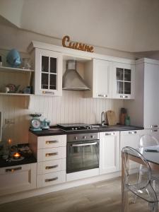 una cucina con armadi bianchi e piano cottura di Solis Domus - Aurora a Ostuni