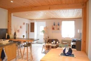 a kitchen and living room with a wooden ceiling at BLEU Seize in Natzwiller