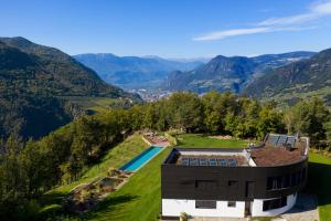 an aerial view of a house with a swimming pool and mountains at VILLA COLLINA VERDE in Bolzano