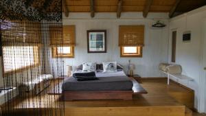 1 dormitorio con 1 cama y algunas ventanas en Cabañas Las Achiras, en Punta del Diablo