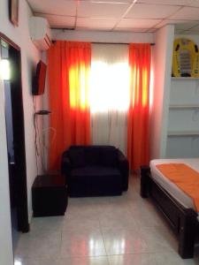Cette chambre comprend un lit, un canapé et une fenêtre. dans l'établissement Cabaña Coveñas, à Coveñas