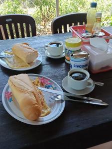 a table with plates of food and cups of coffee at SunRise Villa in Kampong Cham