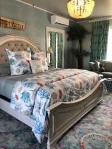 una camera da letto con un grande letto con un copriletto floreale di Avenue O Bed and Breakfast a Galveston