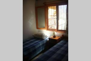 a small bedroom with a bed and a window at Casa en La Aguada Rocha in La Aguada