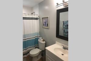 W łazience znajduje się umywalka, toaleta i lustro. w obiekcie Tranquility in Paradise - Cudjoe w mieście Summerland Key