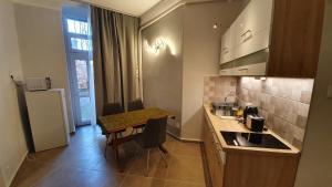 Modern Parkside Garden View Apartment في بودابست: مطبخ صغير مع طاولة صغيرة ومغسلة