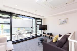 a living room with a couch and a television at Ocean Eleven 3 in Mount Maunganui