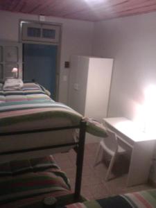 Habitación con cama, mesa y escritorio. en Hostal Amalaya en Salta