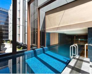 a swimming pool on the side of a building at Midnight Luxe 1 BR Executive Apartment L1 in the heart of Braddon Pool Sauna Secure Parking Wine WiFi in Canberra