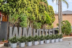 una fila di piante di fronte a una recinzione di WM Bankstown a Bankstown