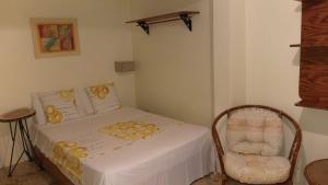 a small bedroom with a bed and a chair at Hotel Magic Tropical in Boca Chica