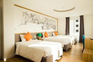 a hotel room with two beds and a painting on the wall at Cocochine Da Nang in Danang